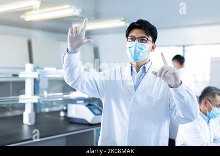 Chinese researchers working in laboratory Stock Photo