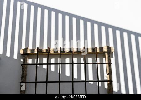 Exterior decoration - window grille in play with the shadows of a fence. Stock Photo