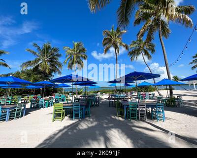 A typical beach restaurant with colorful tables, chairs and umbrellas in the Florida Keys. Stock Photo