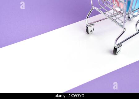 Shopping concept, detail of the back of a grocery cart loaded with paper bags on a pastel lilac and white background. Trendy design with copy space. C Stock Photo