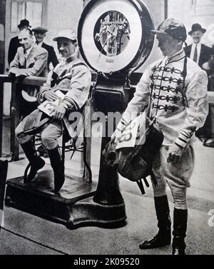 Flat jockey Gordon Richards weighs out for his next race while his brother Cliff Richards awaits his turn. Illustrated news cutting. Sir Gordon Richards (5 May 1904 - 10 November 1986) was an English jockey. He was the British flat racing Champion Jockey 26 times and is often considered the world's greatest jockey ever. He remains the only flat jockey to have been knighted. Stock Photo