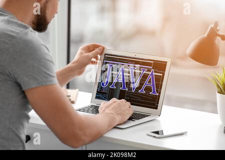 Male programmer writing Java program in office Stock Photo