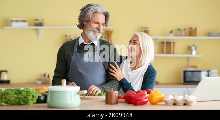 Happy mature couple cooking dinner at home Stock Photo