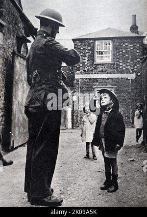 Soldier and child in a street during World War II. Stock Photo