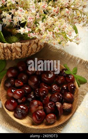 Plate with fresh chestnuts on light background, closeup Stock Photo