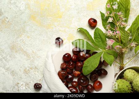 Plate with chestnuts on light background Stock Photo