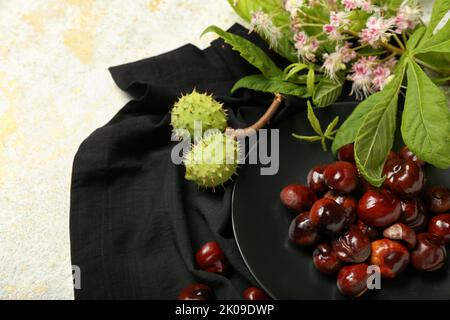 Plate of fresh chestnuts on light background, closeup Stock Photo
