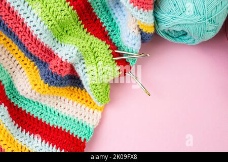 Multicolored crochet lines pattern with hooks and spool, flat lay close up backdrop Stock Photo
