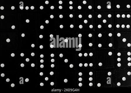 Black dominoes with white dots, full frame background. Abstract solid background. Random ordered. Stock Photo
