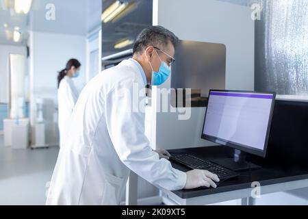 Two Chinese researchers working in laboratory Stock Photo