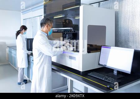 Two Chinese researchers working in laboratory Stock Photo