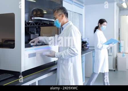 Two Chinese researchers working in laboratory Stock Photo