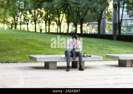 Young Chinese businessman having a headache Stock Photo
