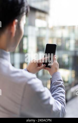 Young Chinese businessman using smart phone Stock Photo