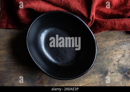 Minimalistic table setting with ceramic bowl and cutlery on wooden table Stock Photo