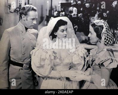 Leslie Howard, Vivien Leigh and Olivia de Havilland in Gone with the Wind, a 1939 American epic historical romance film, adapted from the 1936 novel by Margaret Mitchell. The film was produced by David O. Selznick of Selznick International Pictures and directed by Victor Fleming, and was set in the American South against the backdrop of the American Civil War and the Reconstruction era Stock Photo