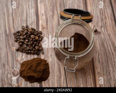 Pile of Ground coffee and coffee beans isolated on white background close-up. glass jar with ground coffee. Stock Photo