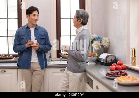 Senior Chinese man and son chatting over coffee Stock Photo