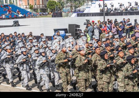 Men and women soldiers of Malaysian Army and Royal Malaysian Navy marching with assault rifles during 65th Malaysia National Day in Kuala Lumpur. Stock Photo