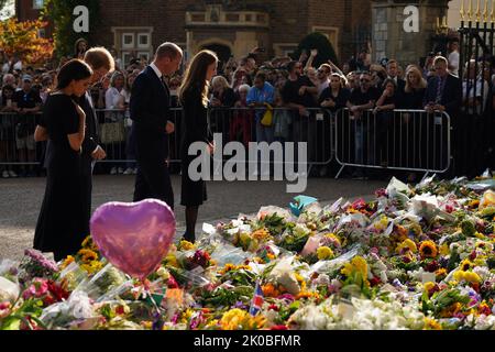 Britain's Prince Harry, Duke of Sussex, (L) his wife Meghan, Duchess of Sussex (2ndL), Britain's Prince William, Prince of Wales (2ndR) and his wife Britain's Catherine, Princess of Wales, (R) look at floral tributes laid by members of the public on the Long walk at Windsor Castle on Saturday on September 10, 2022. King Charles III pledged to follow his mother's example of 'lifelong service' in his inaugural address to Britain and the Commonwealth on Friday, after ascending to the throne following the death of Queen Elizabeth II on September 8. Photo by Photo by The Royal Family/ UPI Stock Photo