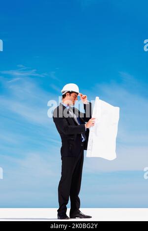 Confident architect looking at a new construction plan. Portrait of confident architect looking at a new construction plan. Stock Photo