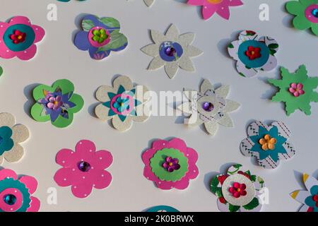 Full frame macro abstract texture design of colorful simple crafted paper flowers on a white background Stock Photo