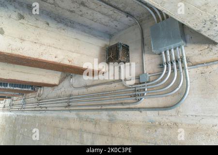 San Antonio, Texas- Electrical pipes under a bridge. View of electric power pipe lines against the concrete walls and ceiling under a bridge. Stock Photo