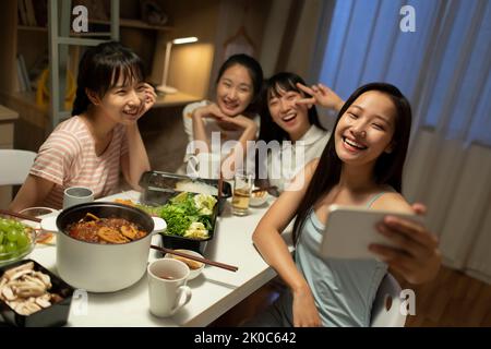 Young Chinese university students having chaffy dish in dormitory Stock Photo