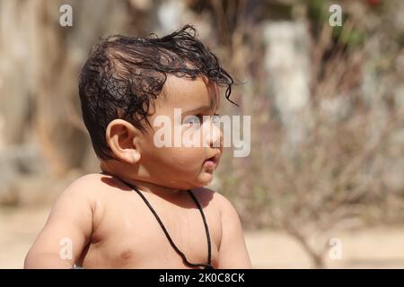 Close-up photo side view of beautiful happy baby boy with smiling faces, Rajasthan India Stock Photo