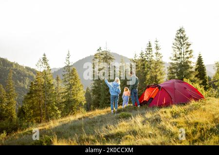 Family with a kid travel with tent in the mountains Stock Photo