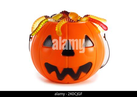 Sweets gummy worms candies in Halloween bag basket jack o lantern pumpkin isolated on white background Stock Photo