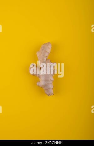 Ginger root on yellow background. Stock Photo