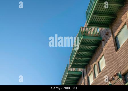 Phoenix, Arizona- View of balconies of a building with bricks from below. Low angle view of an apartment with balconies above the windows against the Stock Photo