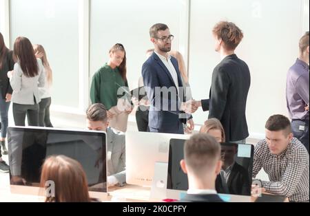 business colleagues shaking hands with each other in the workplace Stock Photo