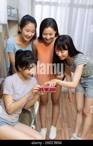 Young Chinese university students using smart phone in dormitory Stock Photo
