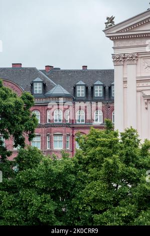 Historic red brick facade next to classic university building and green trees in Lund Sweden Stock Photo