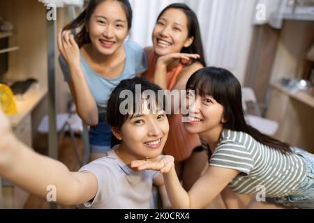 Young Chinese university students taking selfie in dormitory Stock Photo