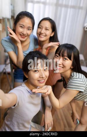 Young Chinese university students taking selfie in dormitory Stock Photo