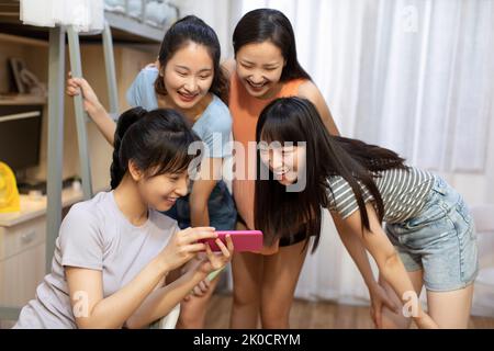 Young Chinese university students using smart phone in dormitory Stock Photo