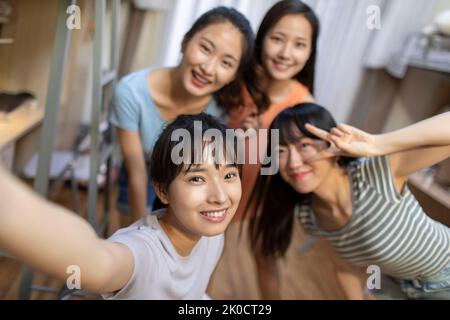 Young Chinese university students taking selfie in dormitory Stock Photo