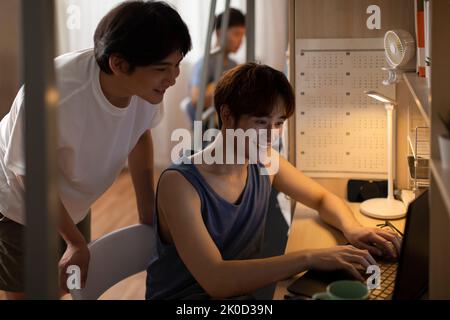 Young Chinese university students using laptop in dormitory Stock Photo