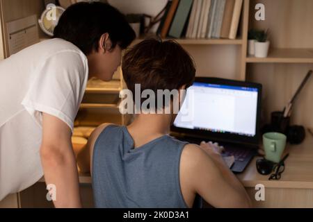 Young Chinese university students using laptop in dormitory Stock Photo