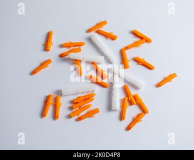 Plastic wall plugs or orange color dowel pin on white isolated background Stock Photo