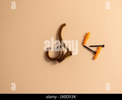 Golden wall hook with screw and plugs on isolated white background Stock Photo