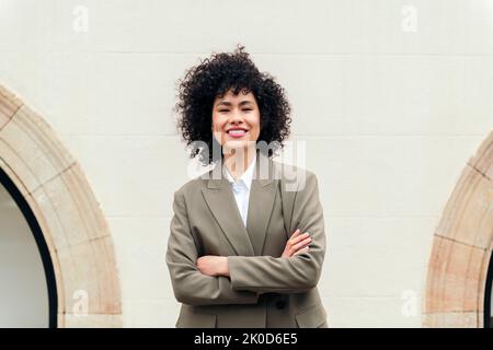 woman with arms crossed smiles looking at camera Stock Photo