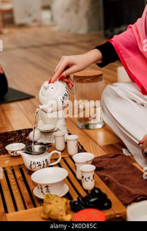 Chinese tea ceremony. A girl pours tea into cups Stock Photo