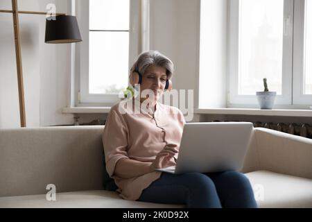 Engaged senior online teacher woman giving learning webinar Stock Photo