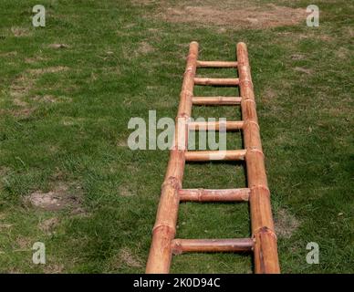 Bamboo ladder laying on a ground in the lawn Stock Photo