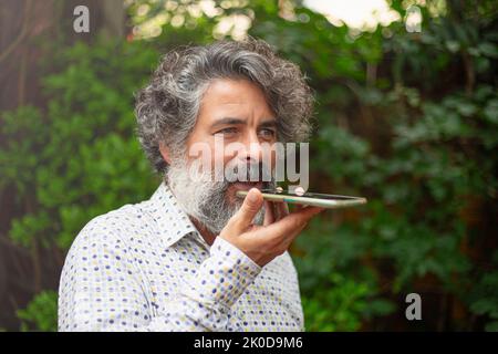 Hipster businessman sends a voice message on his mobile Stock Photo