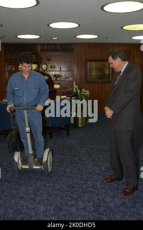 Secretary Mel Martinez, Staff Sampling Personal Transportation Device. Secretary Mel Martinez, Staff Sampling Personal Transportation Device Subject, Secretary Mel Martinez, other senior staff testing the Segway Human Transporter during visit to HUD Headquarters by the Segway's inventor, Dean Kamen. Stock Photo